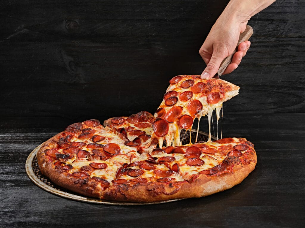 picking up a slice of pizza